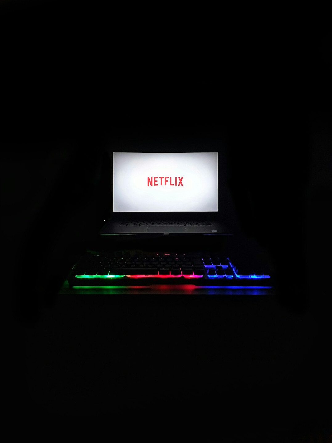 Pantalla de laptop mostrando un editor de codigo con sintaxis de colores en una habitacion oscura