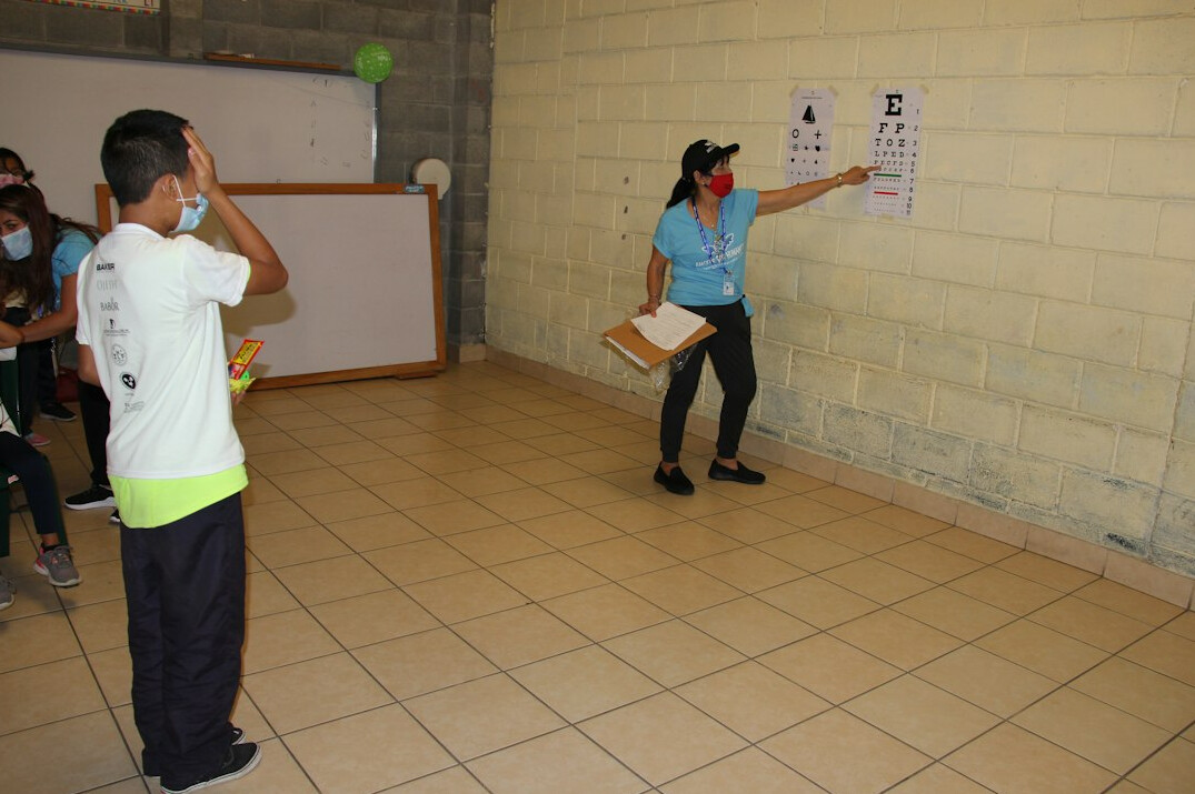 Instructor mexicano enseñando programacion y señalando una pantalla