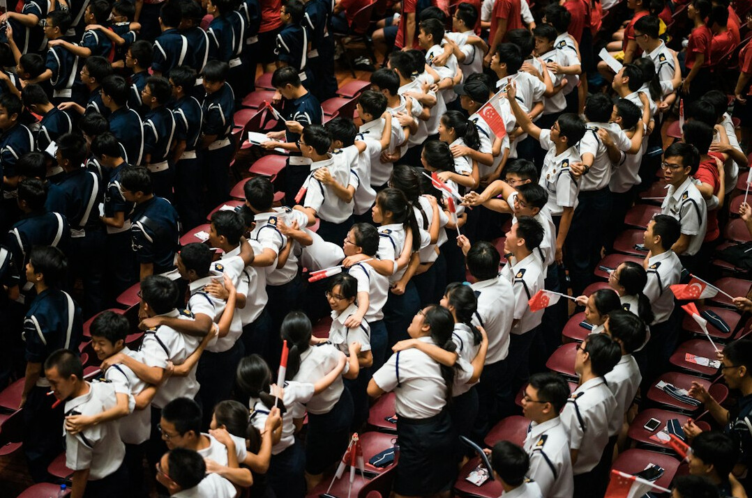 Grupo de estudiantes mexicanos trabajando juntos con laptops en un salon de clases