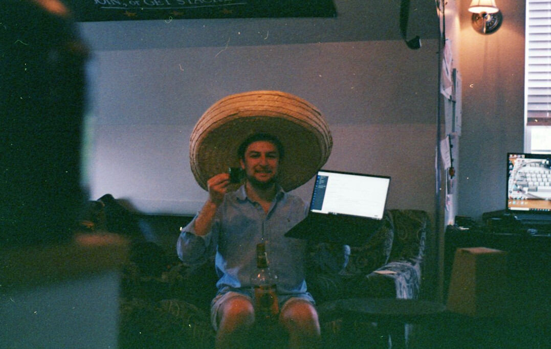 Joven mexicano programando en su laptop en un estudio moderno y luminoso